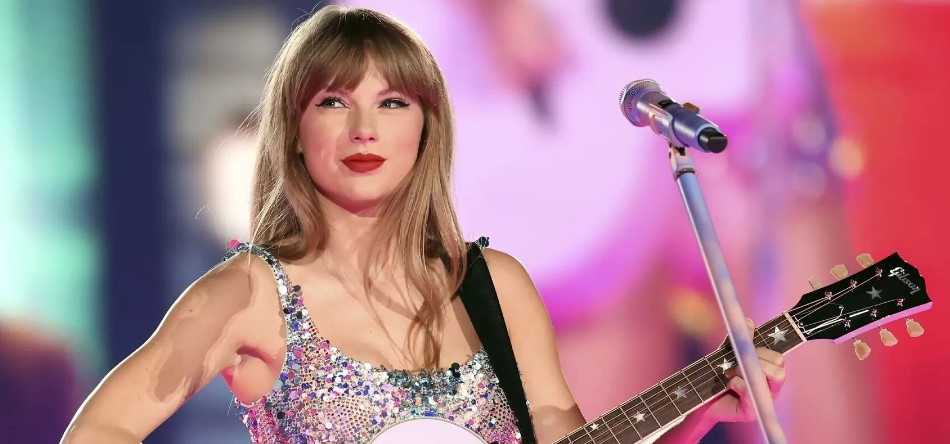 Taylor Swift con su traje y guitarra de la era Lover